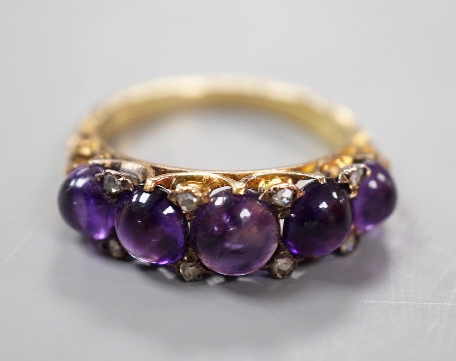 A late Victorian yellow metal and five stone graduated cabochon amethyst set half hoop ring, with rose cut diamond chip spacers, size M, gross weight 4.7 grams.